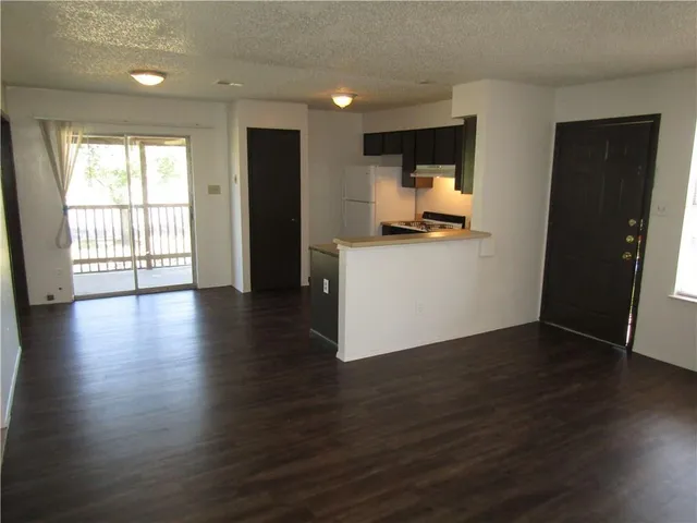 a kitchen with stainless steel appliances a refrigerator and wooden floor