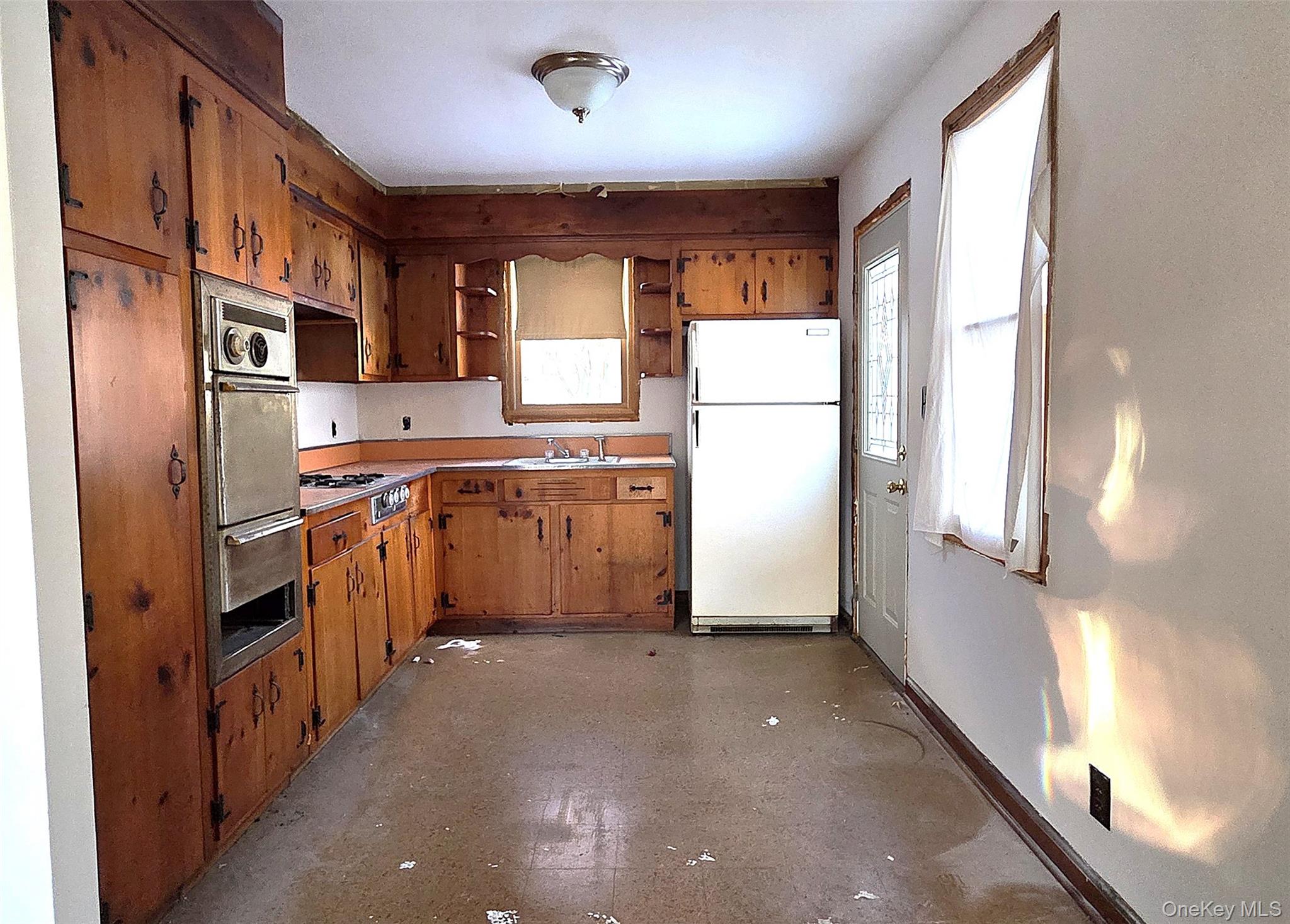 1716 A Main Street Peekskill, NY 10566 - Photo 6 of 13 a kitchen with stainless steel appliances granite countertop a refrigerator a sink dishwasher a stove with white cabinets and wooden floor
