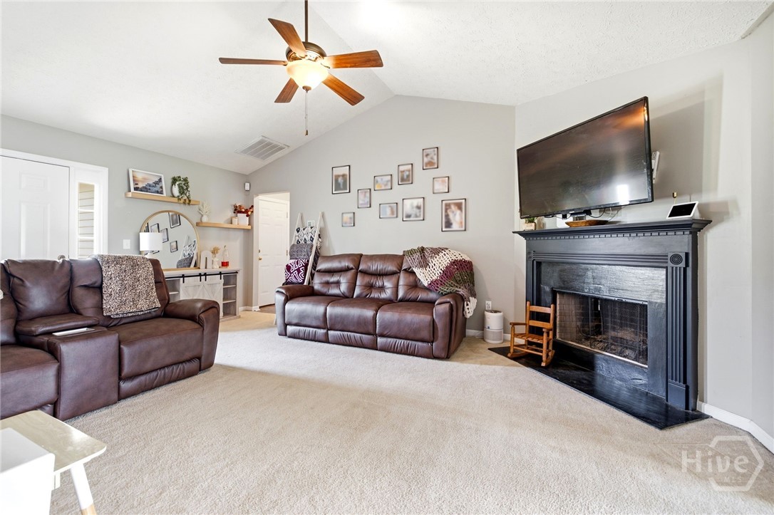121 Crestview Drive Carnesville, GA 30521 - Photo 6 of 28 Living room featuring vaulted ceilings, a ceiling fan with integrated lighting, and light-colored carpeting