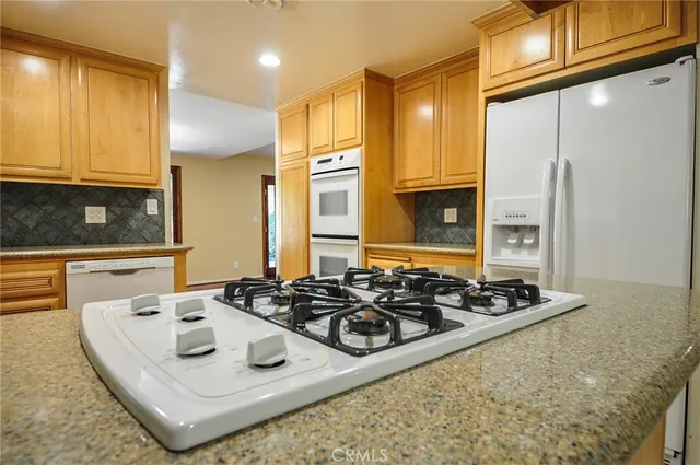 a kitchen with stainless steel appliances granite countertop a sink stove and cabinets