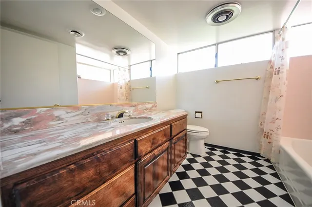 a bathroom with a granite countertop sink toilet a mirror and shower
