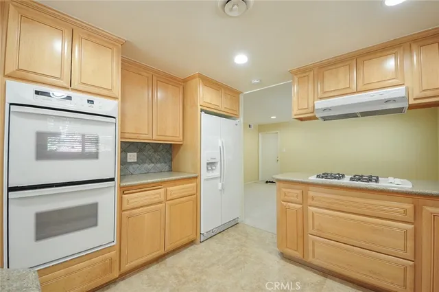 a kitchen with white cabinets and white appliances