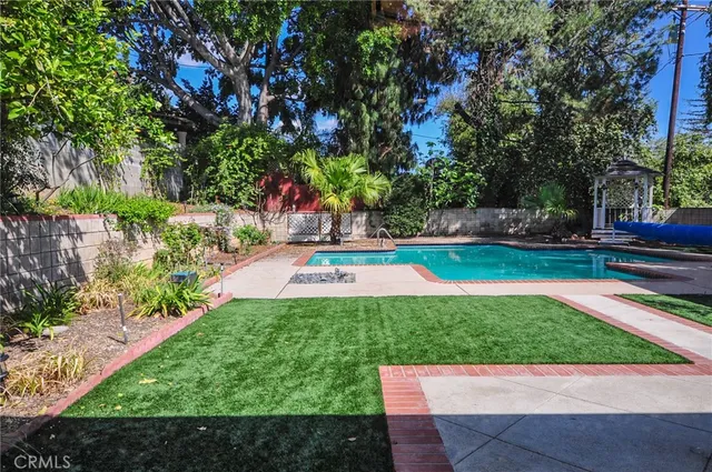 a view of backyard with swimming pool