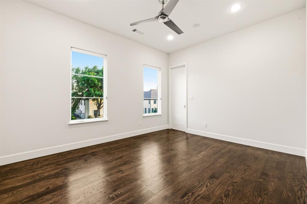 6523 Northwood Road Dallas, TX 75225 - Photo 29 of 36 an empty room with wooden floor chandelier fan and windows