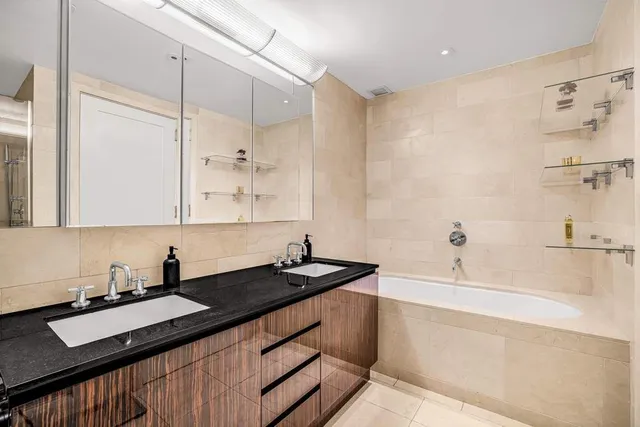 a bedroom with a bed and a dresser with wooden floor