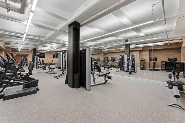 a kitchen with a dining table chairs cabinets and stainless steel appliances