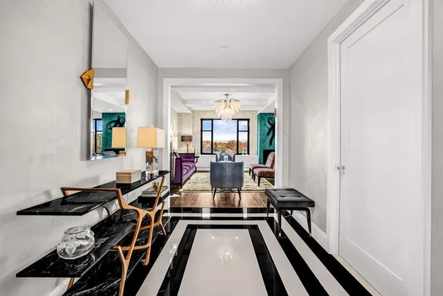 a view of a dining room and livingroom with furniture wooden floor a chandelier
