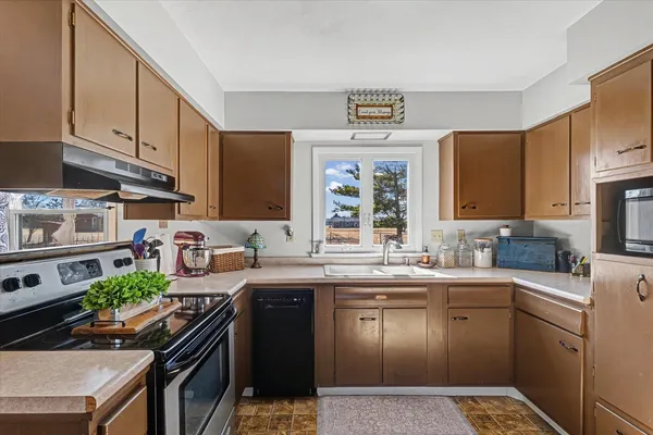 a kitchen with stainless steel appliances granite countertop a sink stove and cabinets