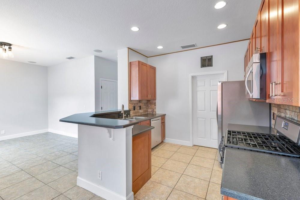 125 Manor View Lane DeLand, FL 32724 - Photo 11 of 37 a kitchen with stainless steel appliances granite countertop a stove a refrigerator and a cabinets