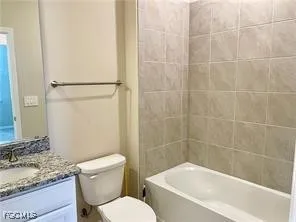 a white toilet sitting next to a bath tub