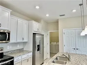 a kitchen with granite countertop white cabinets and stainless steel appliances