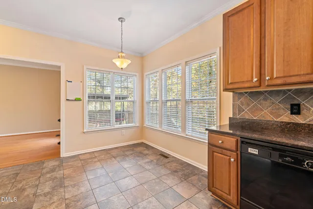a kitchen with granite countertop a stove top oven a sink a counter space and cabinets