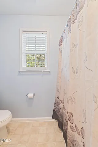 a view of empty room with wooden floor and chair