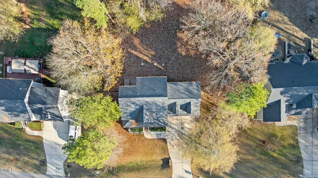 an aerial view of residential houses with outdoor space and trees