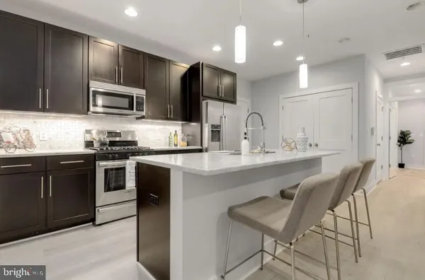 a kitchen with kitchen island granite countertop a sink and stainless steel appliances