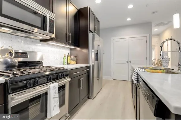 a kitchen with stainless steel appliances granite countertop a stove and a refrigerator