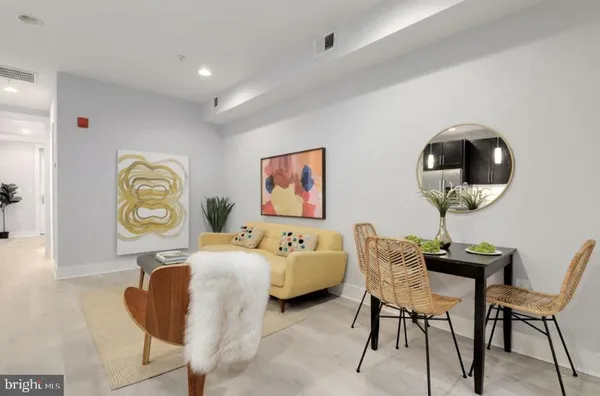 a living room with furniture and a painting on the wall