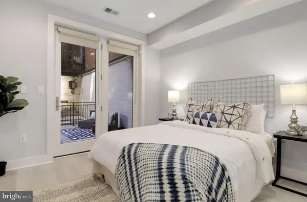 a bedroom with a large bed and a chandelier