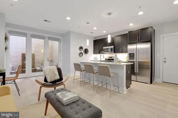 a kitchen with stainless steel appliances kitchen island granite countertop a refrigerator a stove a sink dishwasher with a dining table and chairs