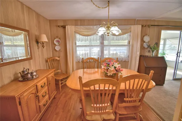 a view of a dining room with furniture a chandelier and wooden floor