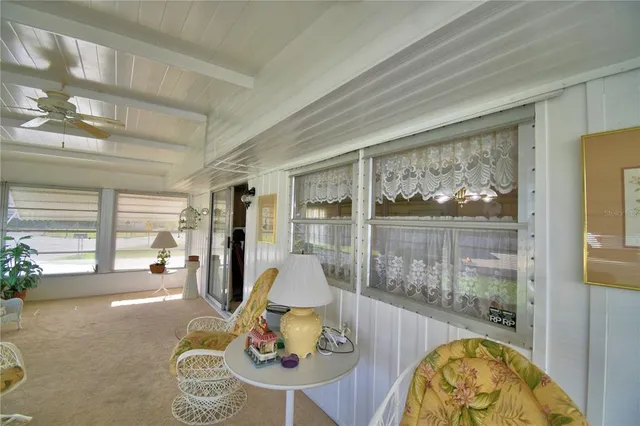 a dining room with furniture and a floor to ceiling window