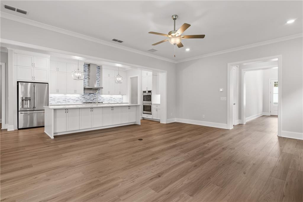 10025 Ruppel Lane Johns Creek, GA 30005 - Photo 6 of 23 a view of a kitchen with a stove cabinets a ceiling fan and wooden floor