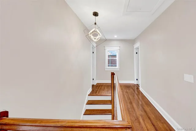 a view of a hallway with wooden floor and white walls