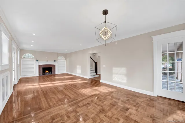 a view of an empty room with a fireplace and a window