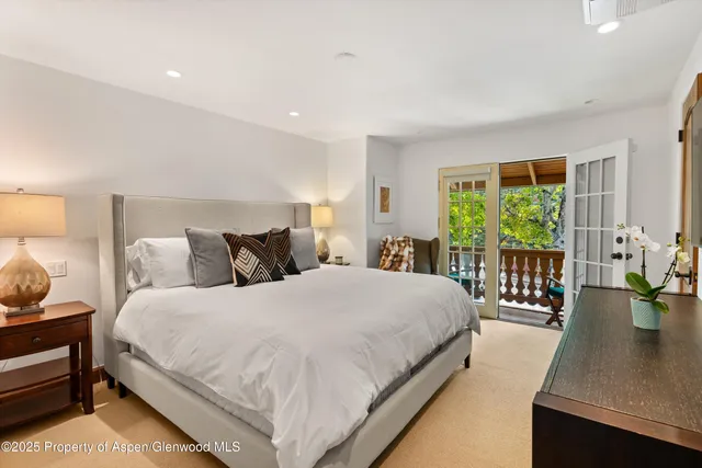 a large bedroom with a bed and wooden floor