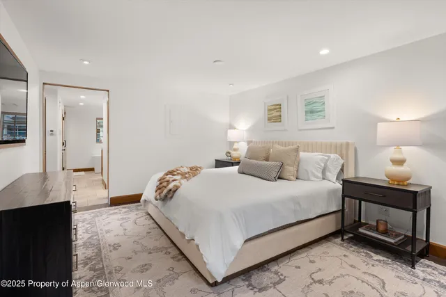 a bedroom with a bed and a lamp on dresser