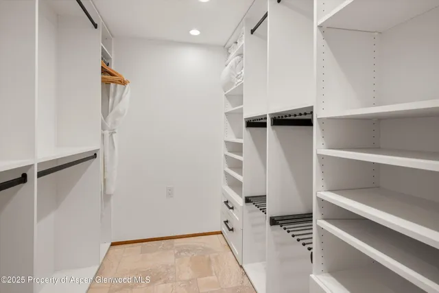a view of walk in closet with empty racks