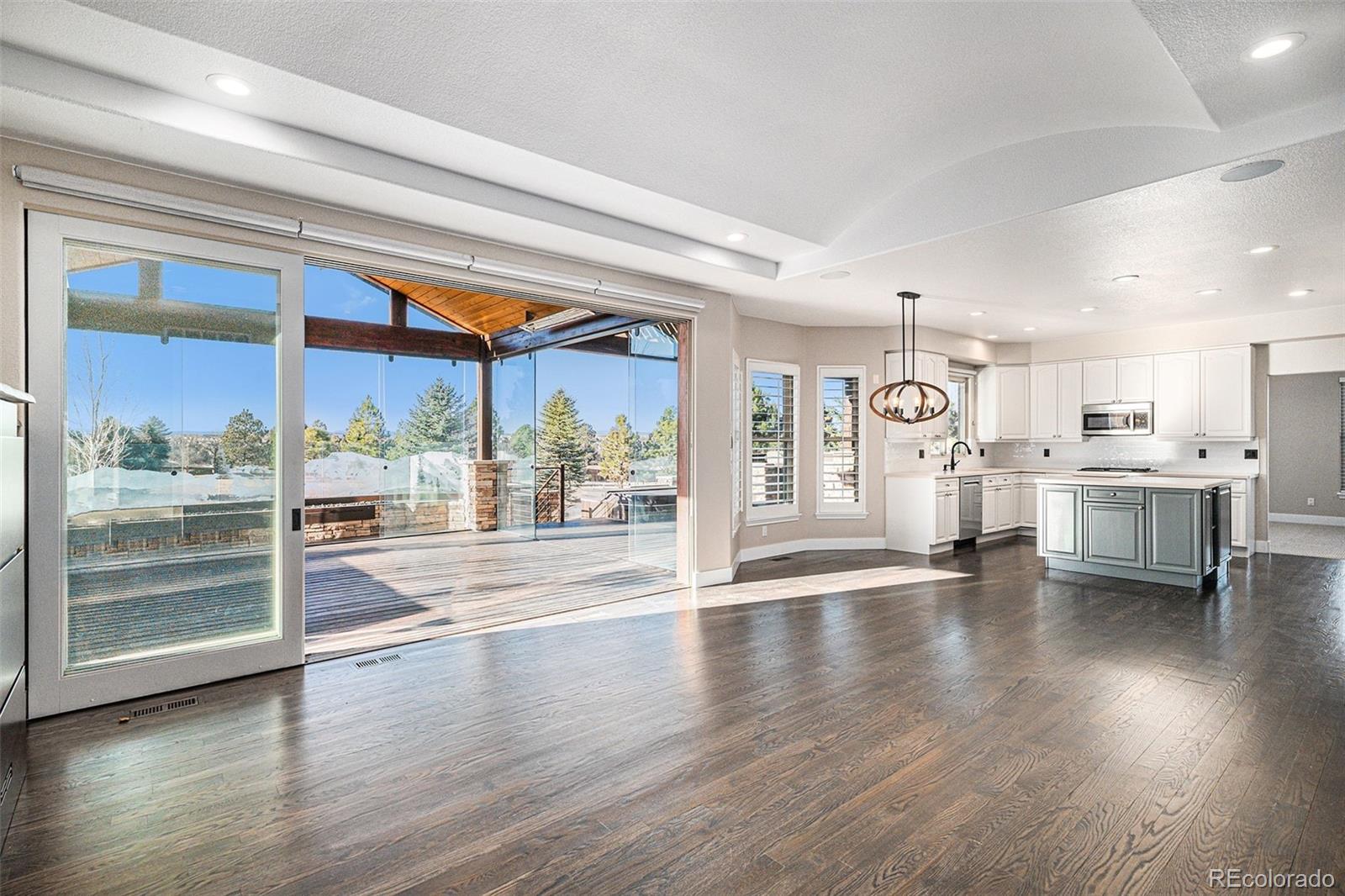 12665 South Robinson Ranch Boulevard Parker, CO 80134 - Photo 8 of 38 a view of a living room and kitchen with furniture wooden floor and windows