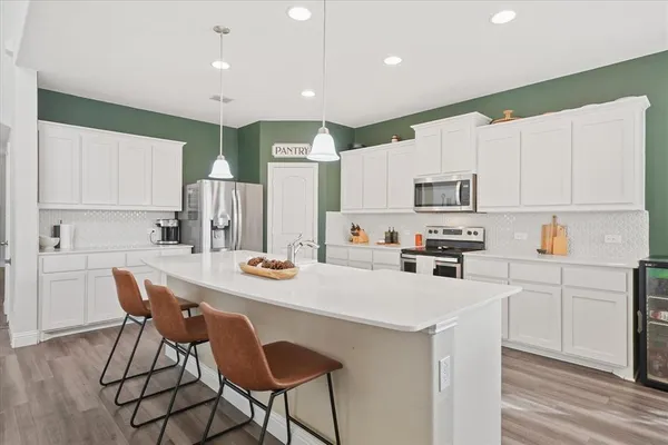 a kitchen with appliances a sink and cabinets