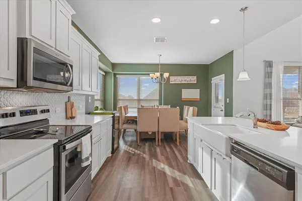 a kitchen with sink stove and cabinets