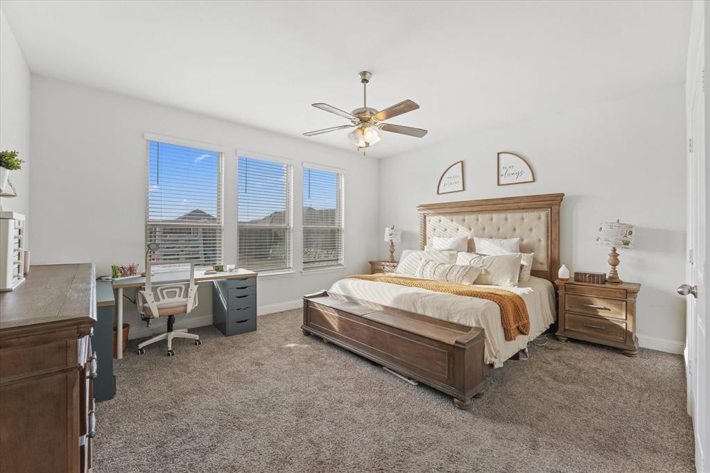 3725 Ranchers Ridge Krum, TX 76249 - Photo 19 of 38 a spacious bedroom with a bed a chandelier and a large window