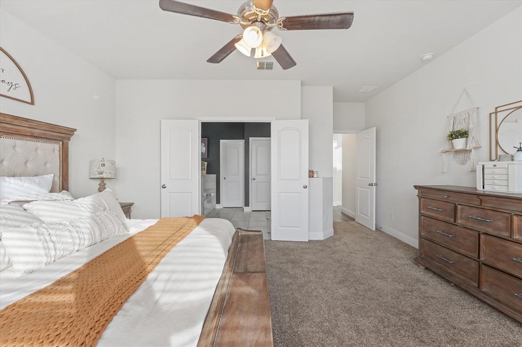3725 Ranchers Ridge Krum, TX 76249 - Photo 21 of 38 a bedroom with a bed and a chandelier