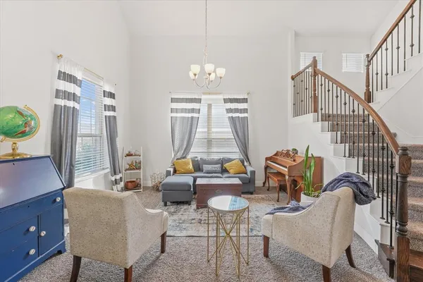 a living room with furniture chandelier and a window