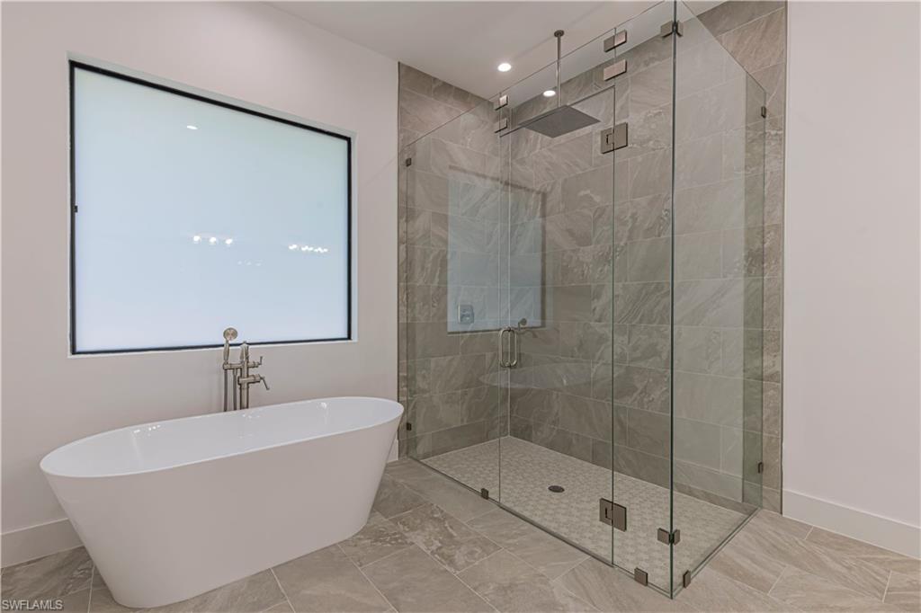 3074 Pine Tree Drive Naples, FL 34112 - Photo 11 of 18 a bathroom with a bathtub and shower