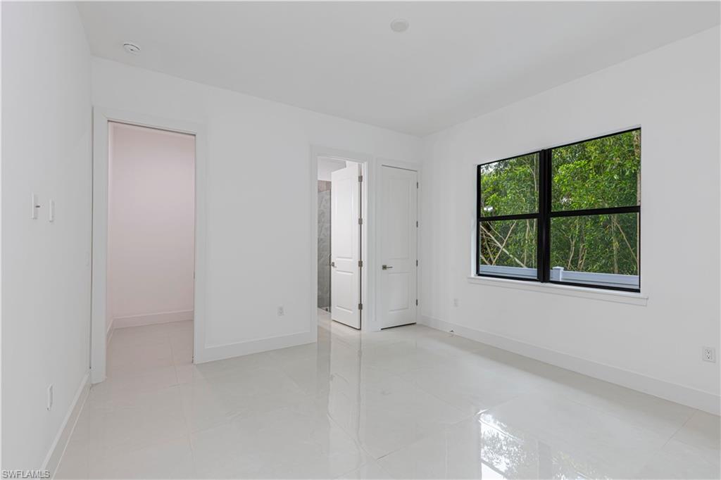 3074 Pine Tree Drive Naples, FL 34112 - Photo 14 of 18 an empty room with windows