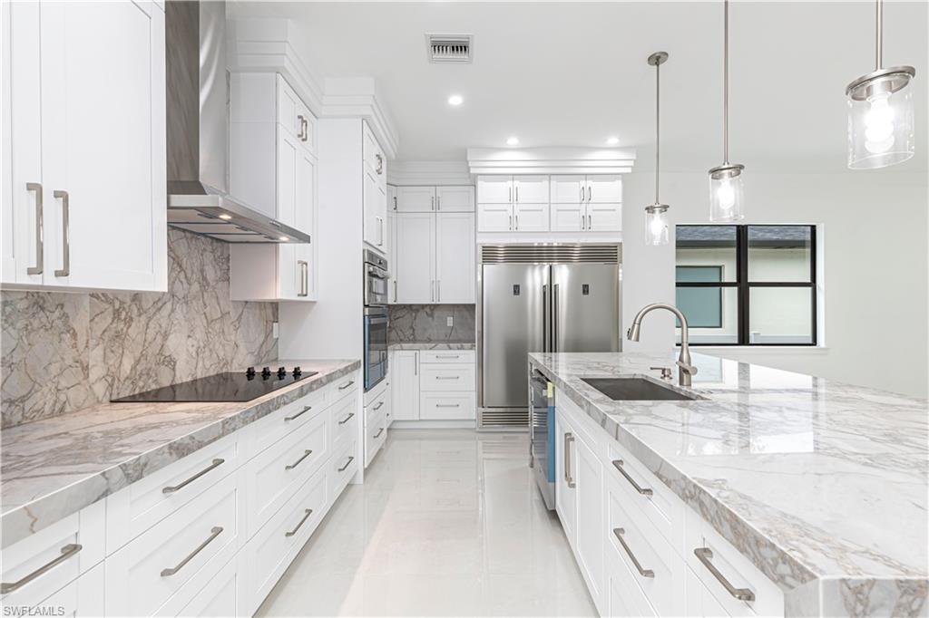 3074 Pine Tree Drive Naples, FL 34112 - Photo 5 of 18 a large kitchen with kitchen island a sink stove and refrigerator