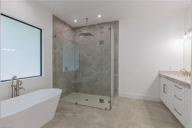 a bathroom with a tub shower sink and mirror