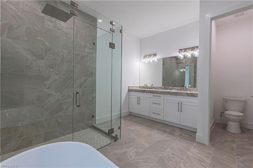 3074 Pine Tree Drive Naples, FL 34112 - Photo 10 of 18 a bathroom with a sink a toilet and shower