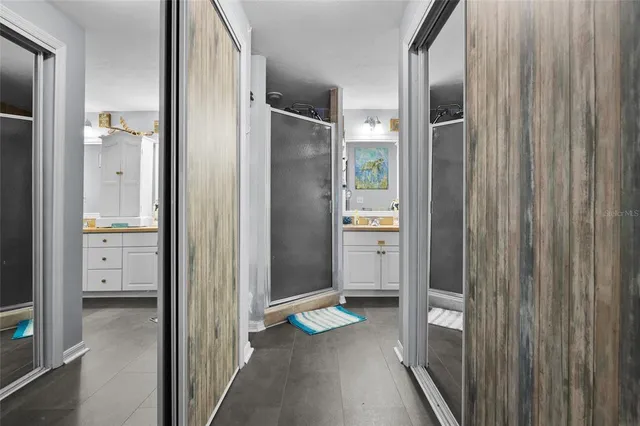 a bathroom with double vanity sinks a mirror a vanity and a shower