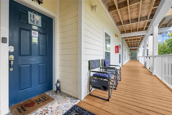 a view of a balcony with wooden floor and chair