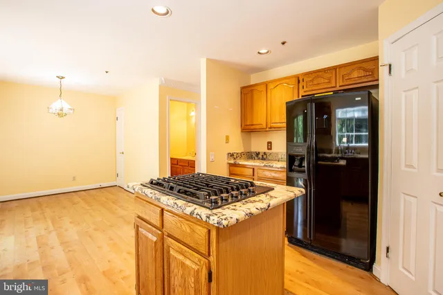 a kitchen with a refrigerator and a stove top oven