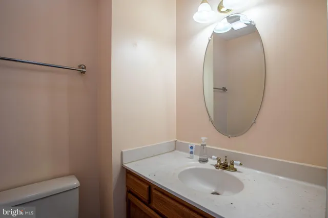 a bathroom with a sink vanity mirror and toilet