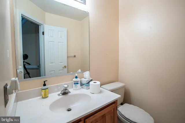 a bathroom with a sink a toilet and mirror
