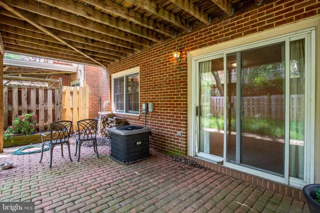 a view of a patio with chairs and potted plants