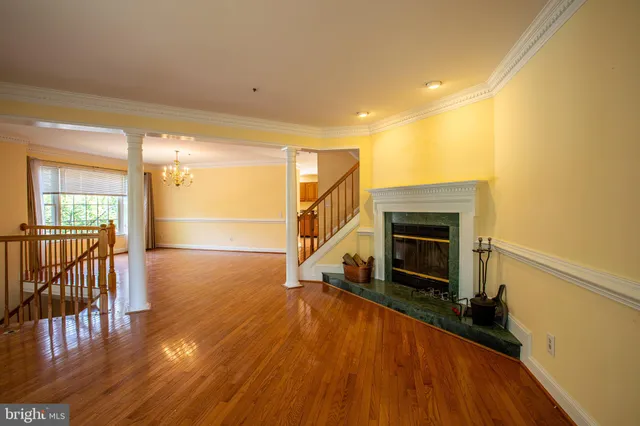 a view of a livingroom with wooden floor and a fireplace