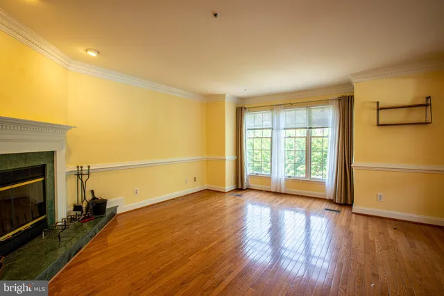 a view of empty room with wooden floor and fireplace